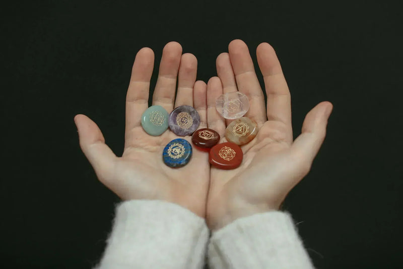 Galet de pierre correspondant aux sept chakras poser dans deux mains ouvertes