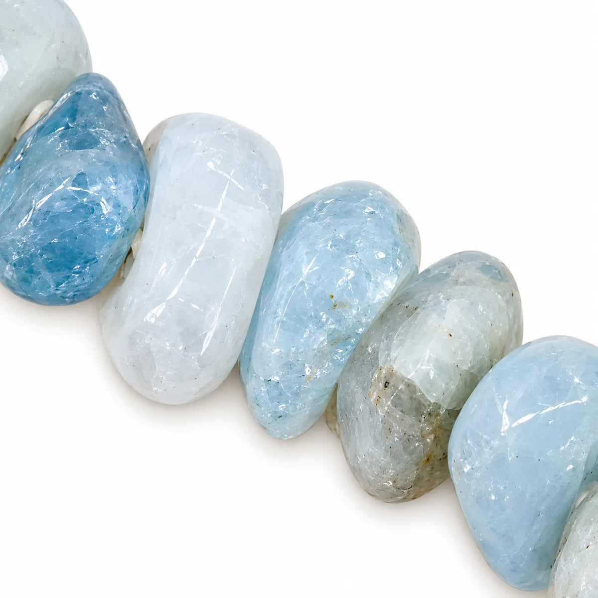 Gros plan sur les perles baroques du bracelet en aigue-marine véritable, révélant les nuances bleu glacier, bleu pâle et gris-vert des pierres naturelles.