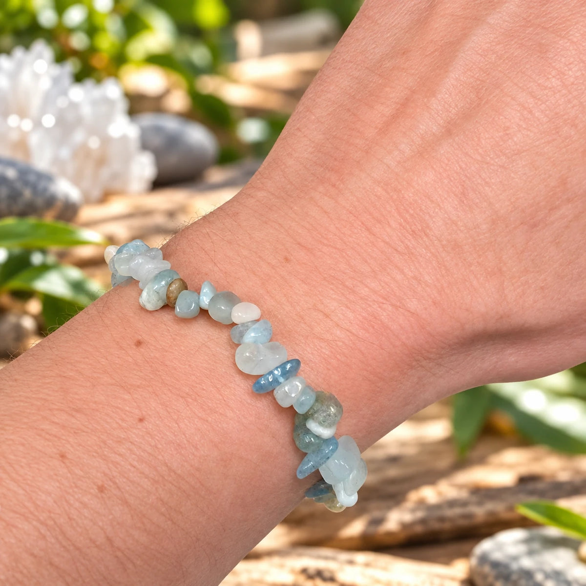 Bracelet mixte en véritable aigue-marine porté au poignet, composé de pierres baroques bleu clair et vert d’eau, photographié dans une ambiance naturelle et apaisante.