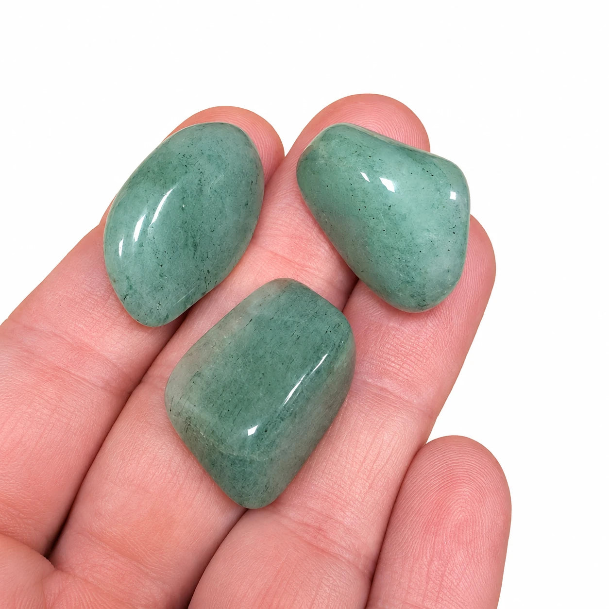 Trois pierres naturelles aventurine verte roulée de Tanzanie présentées dans la main, permettant d'apprécier leur taille de 2 à 3 cm, leur finition polie et leur couleur vert doux naturelle.