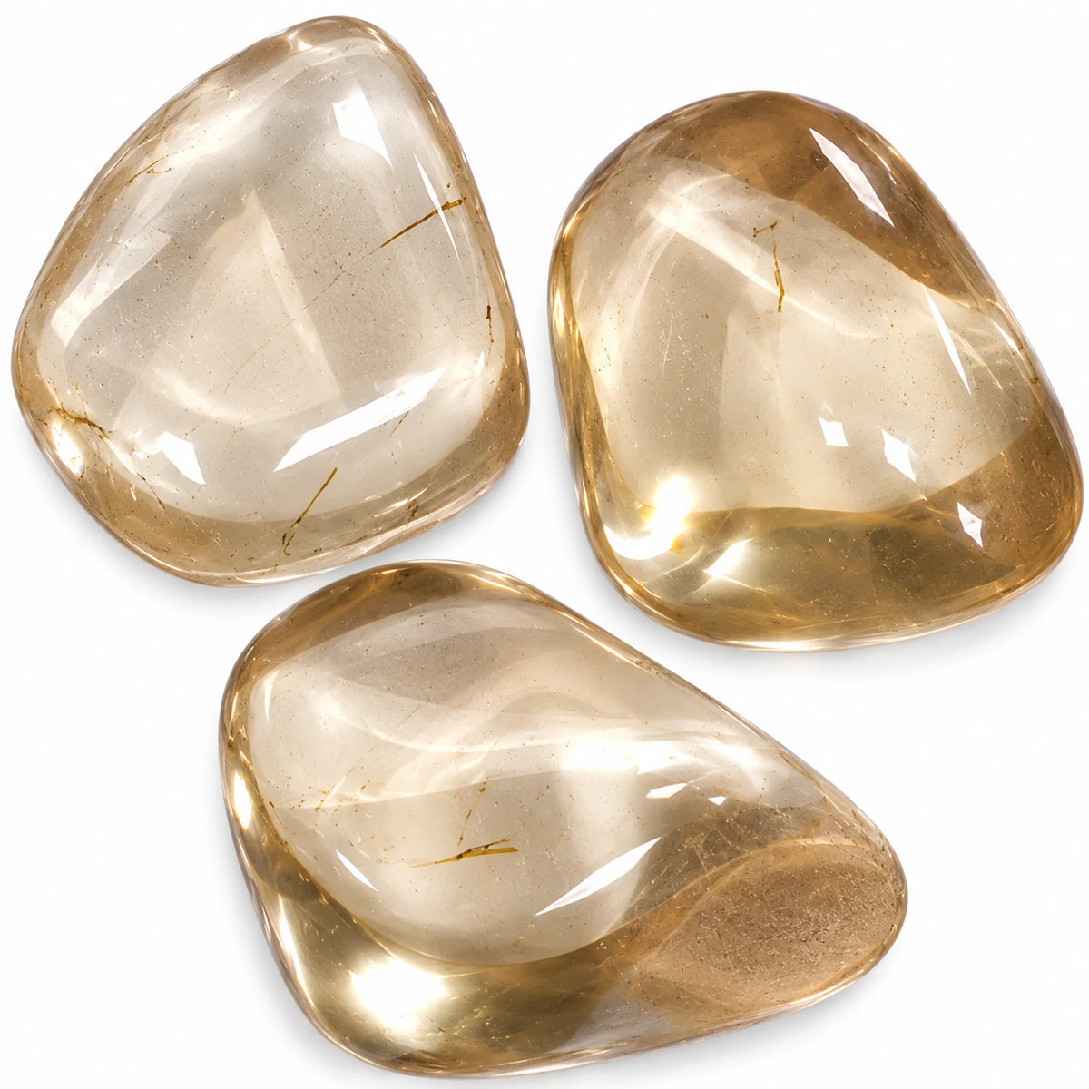 Gros plan sur trois pierres roulées naturelles Bytownite, ou labradorite dorée de Madagascar, aux teintes beige doré et translucides