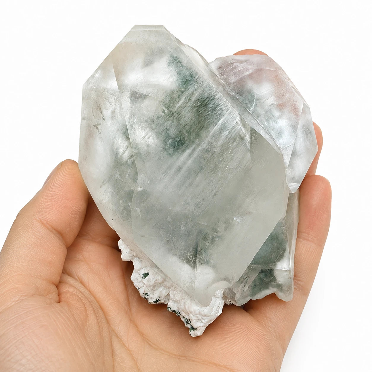 Pierre de collection en calcite cristal brut d'Inde avec mordenite et chlorite tenue dans une main, permettant d'apprécier les dimensions réelles du spécimen minéral.