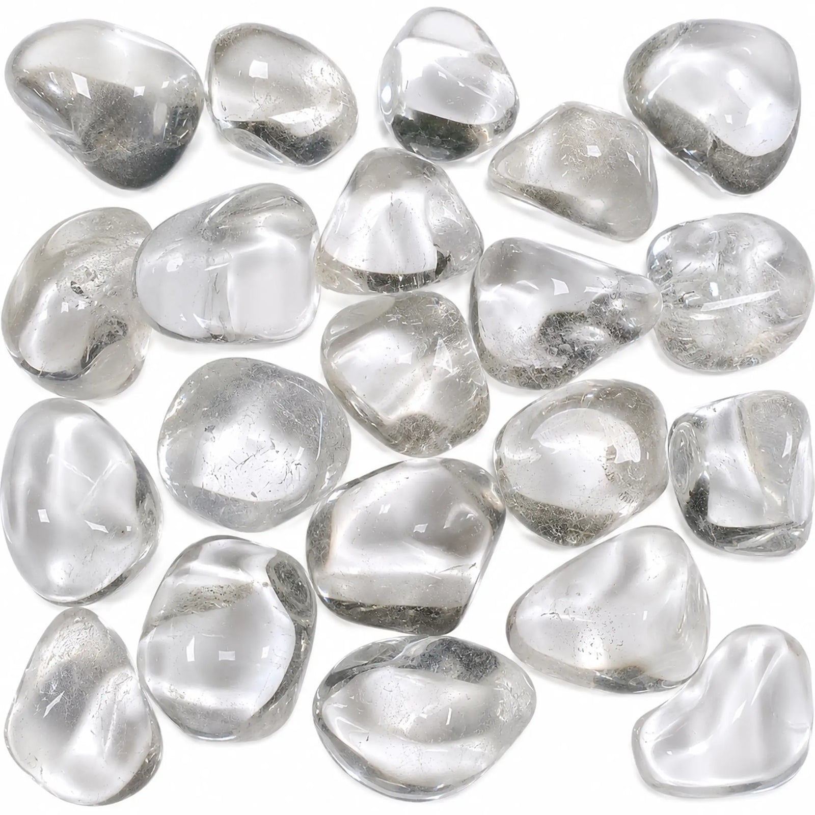 Pierre naturelle cristal de roche roulé du Brésil – assortiment de pierres roulées transparentes en quartz naturel sur fond blanc pour lithothérapie, collection et décoration.