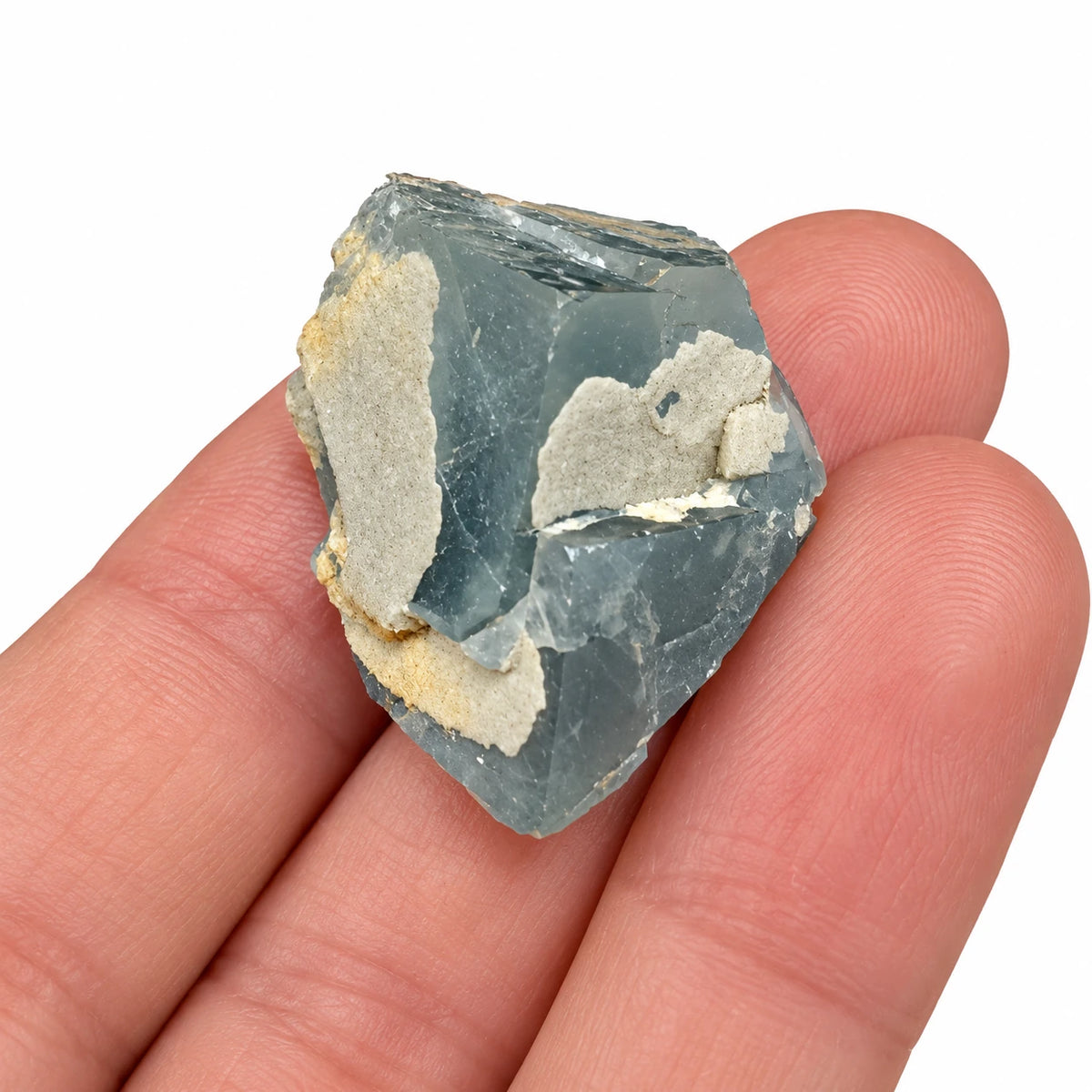Fluorite bleue avec quartz de Langeac présentée sur les doigts, montrant les proportions du spécimen de collection