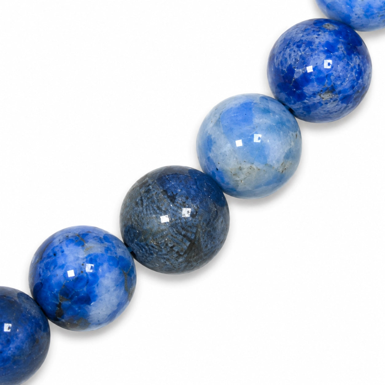 Gros plan sur des perles rondes de 6 mm en véritable lapis lazuli, révélant les nuances naturelles de bleu et les détails de la pierre authentique utilisée pour ce bracelet.
