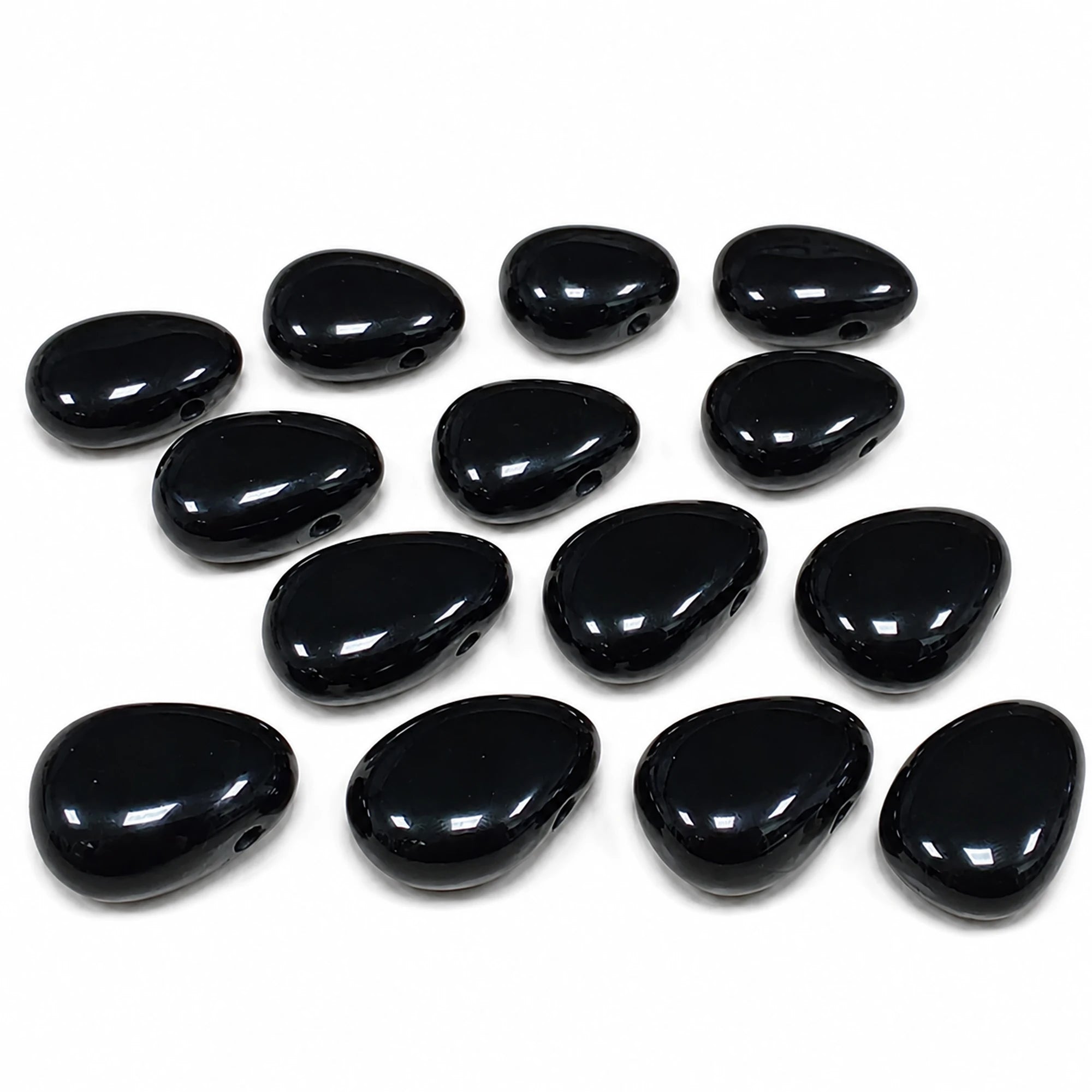 Lot de pendentifs en obsidienne noire du Mexique, pierres percées naturelles polies, finition brillante, sélection de pendentifs pour lithothérapie sur fond blanc.