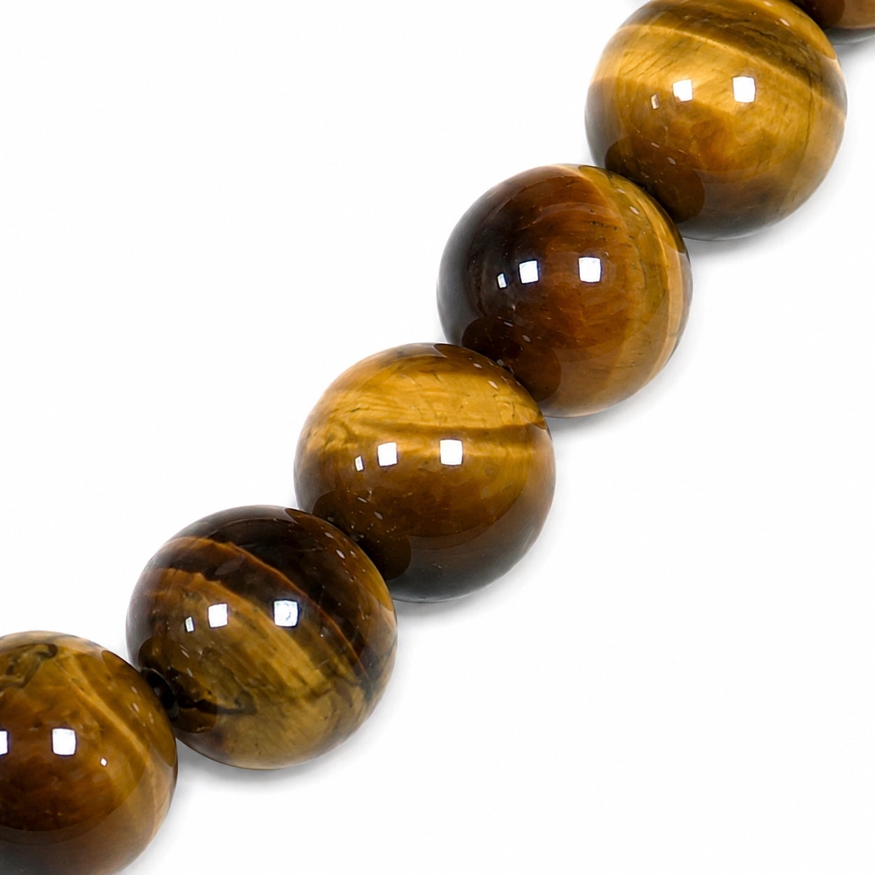 Gros plan des perles rondes de 8 mm d'un bracelet en véritable Œil de tigre, mettant en valeur les reflets chatoyants dorés, bruns et noirs de cette pierre naturelle polie.