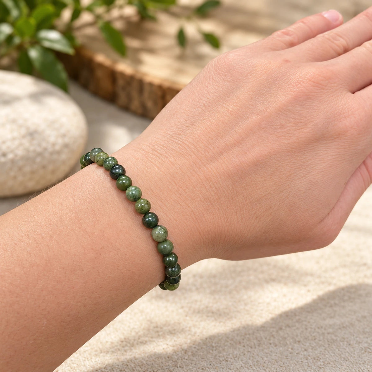 Bracelet mixte en serpentine à perles rondes de 6 mm porté au poignet, dans un décor aux tons naturels