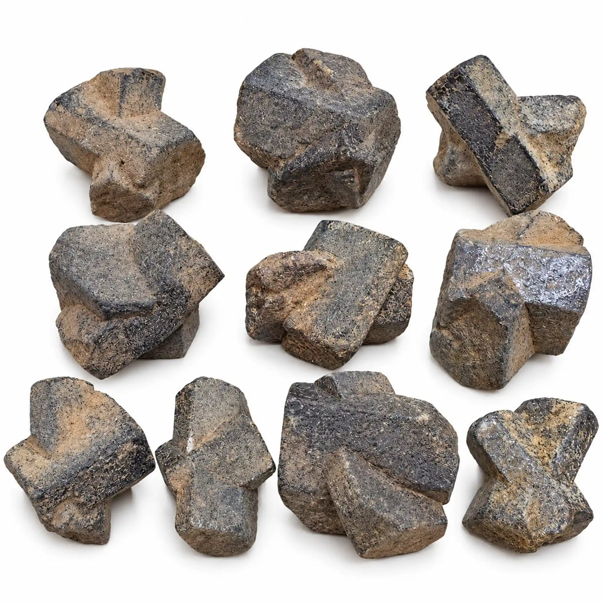 Ensemble de staurolites de Bretagne sur fond blanc, avec différentes formes de macles en croix et des traces de gangue brune