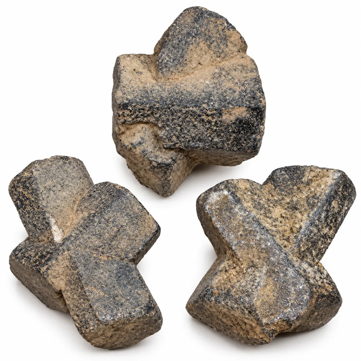 Gros plan de trois staurotides de Baud, aux cristaux entrecroisés, avec des reliefs bruts sombres et des zones de gangue beige