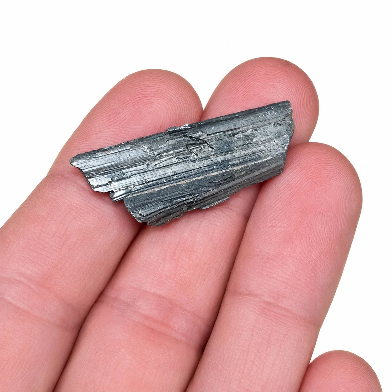 Cristal brut de Stibine à porter sur soi dans une main, pierre naturelle de Chine aux cristaux métalliques gris argenté, montrant la taille réelle du spécimen.