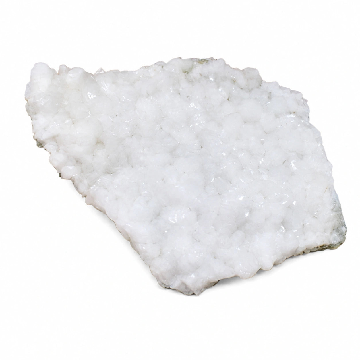 Druse de stilbite naturelle provenant du Hvalfjörður en Islande, présentant une cristallisation blanche brillante sur matrice rocheuse, spécimen minéralogique de collection photographié sur fond blanc.