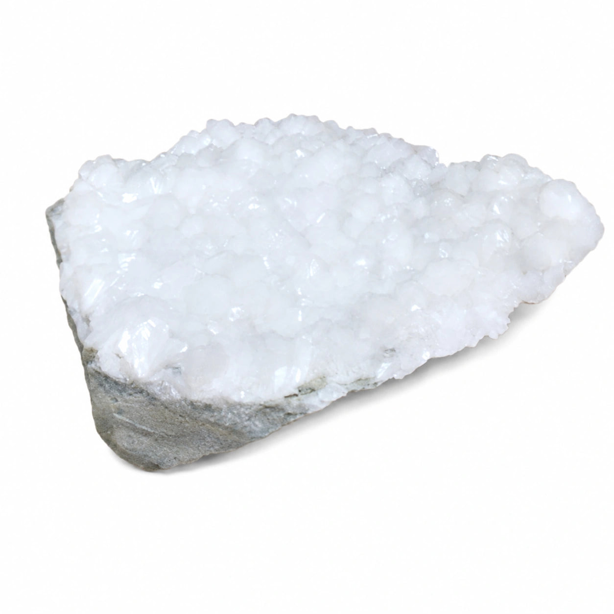 Druse de stilbite blanche avec matrice rocheuse naturelle, découverte dans le Hvalfjörður en Islande, mettant en valeur le relief cristallin et la structure minérale authentique.