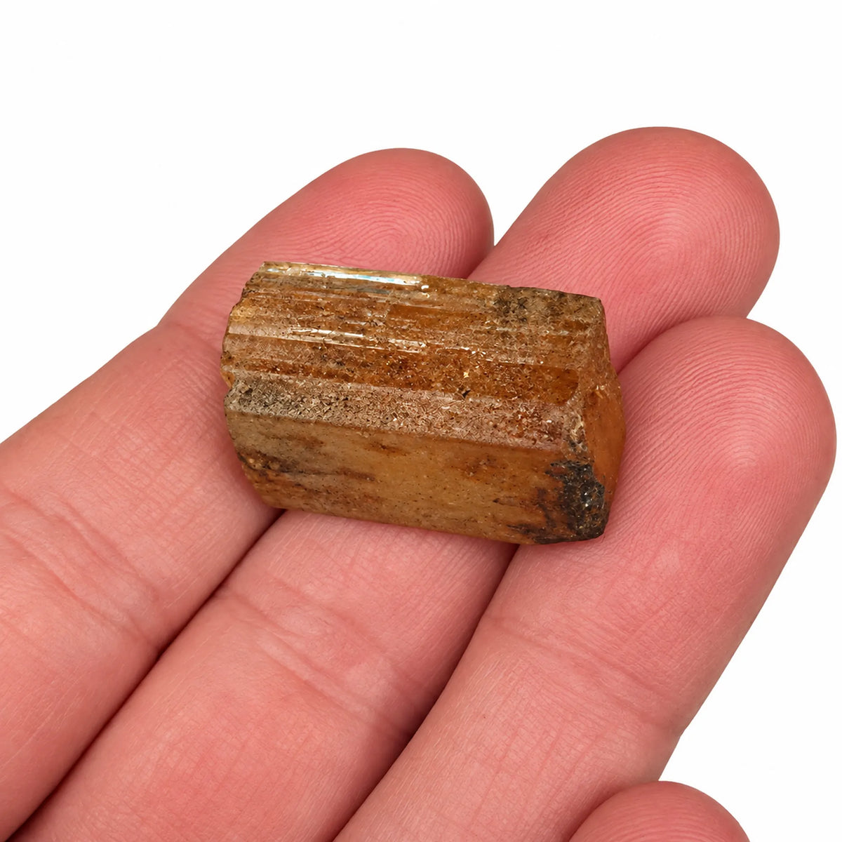 Topaze impériale brute d’Ouro Preto, Brésil, présentée dans la main pour montrer la taille et les détails du cristal