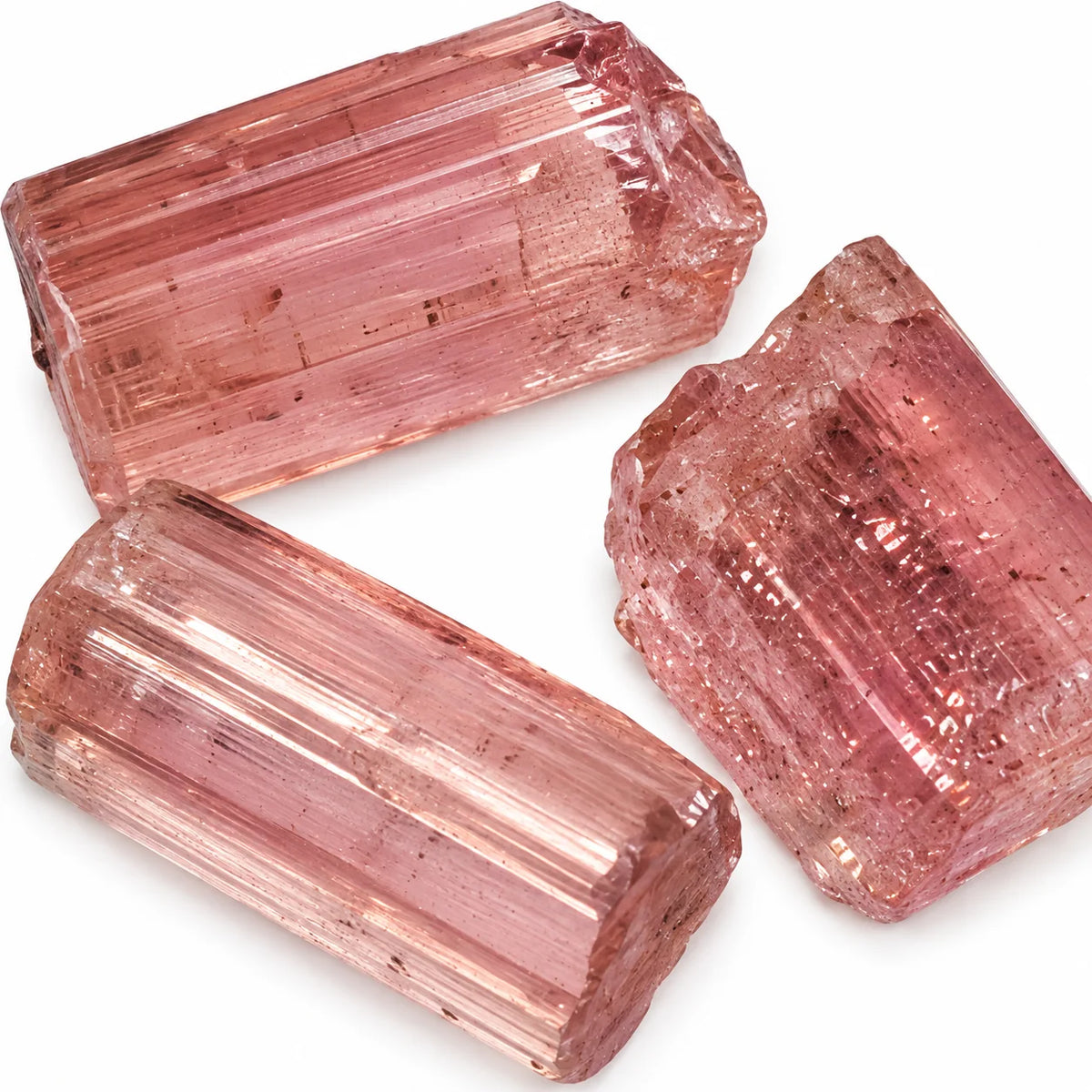 Zoom sur trois petits cristaux bruts de tourmaline rose rubellite de Madagascar, cristaux naturels translucides aux nuances rose pâle
